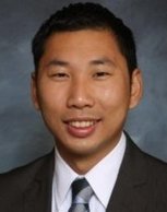 Profile image of Andy Chen, Director of Doctoral Programs. Andy is smiling, wearing a dark suit and tie.